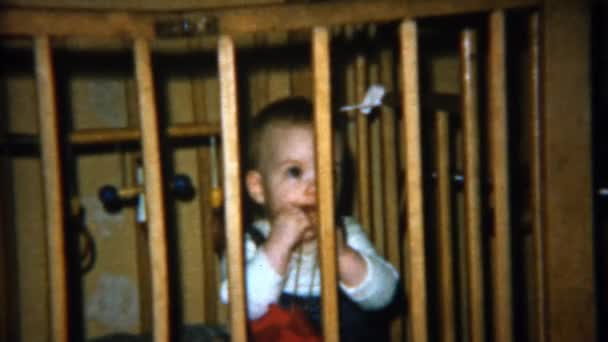 Baby bakom fängelse spjälsäng barer tuggar — Stockvideo