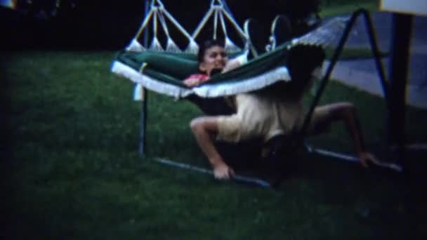 Kid goofing on outdoor summer hammock — Stock Video