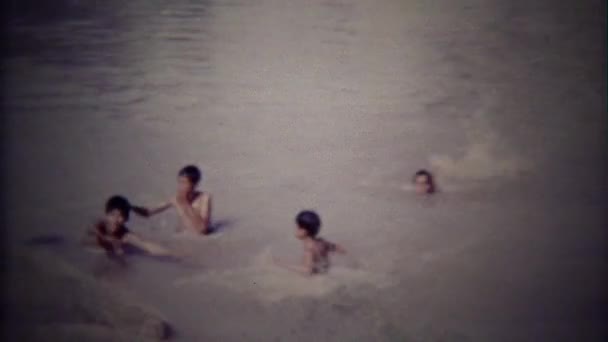Děti si hrají v kalné vodě plavání otvor — Stock video