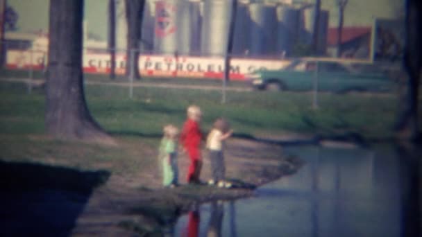 Дети играют в пруду с сточными водами — стоковое видео