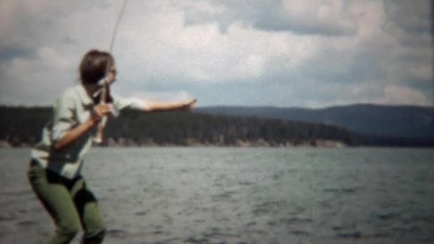 Chica capturas trucha pescado en el lago — Vídeos de Stock