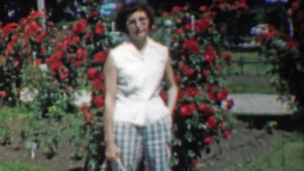 Donna posa mendicante in cespugli di rose — Video Stock