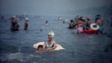 Anne oğlu okyanusta yüzmek için öğretim