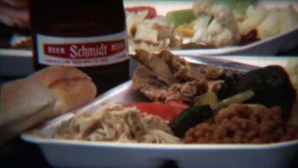 Plate full of food next to Schmidt beer bottle — Stock Video