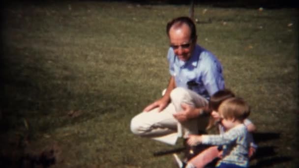 Děda si hraje s dětmi na trávník — Stock video