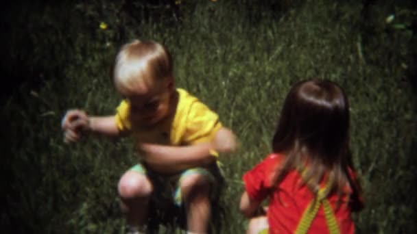 Bruder und Schwester toben im Gras herum — Stockvideo