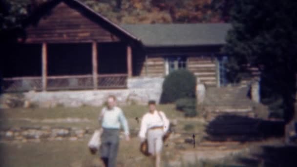 Couple leaving log cabin going — Stock Video
