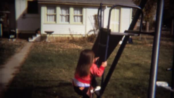 Toddler girl goes down backyard slide — Stock Video