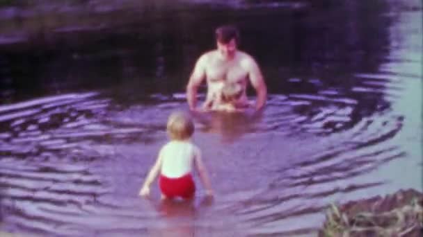 Tata i dzieci grać w jeziorze — Wideo stockowe