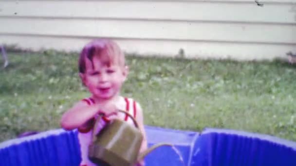 Menino adicionando água para piscina kiddie — Vídeo de Stock