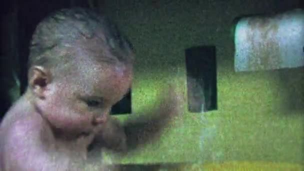 Baby planscht Wasser in Wanne aufblasbares Spielzeug — Stockvideo