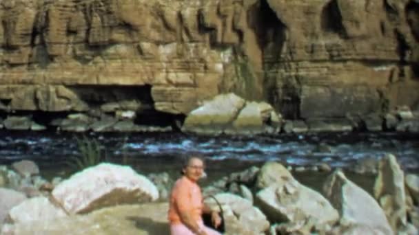 Kobieta siedzi na skale w pobliżu kanionu rzeki — Wideo stockowe