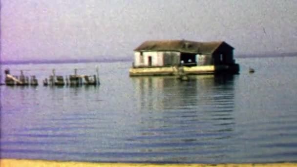 Abandoned ramshackle house floating calm lake — Stock Video