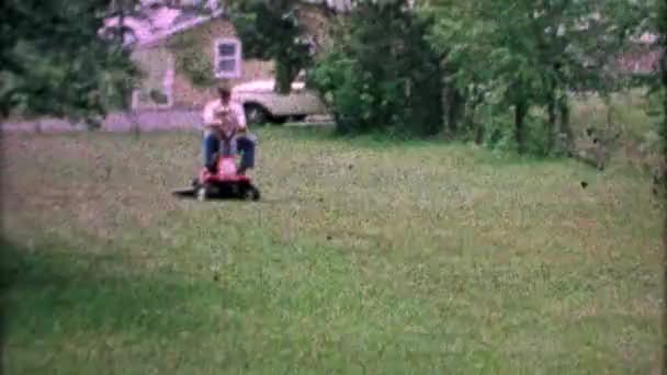 Vater lässt Sohn Rasenmäher fahren — Stockvideo