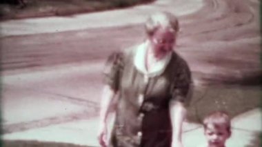 Banliyö yürümeye başlayan çocuk ile yürürken büyükanne 