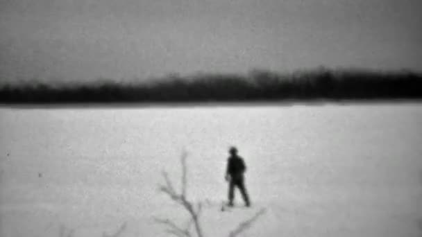 Человек на лыжах пересекает замерзшее озеро — стоковое видео
