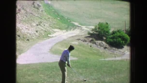 Woman driving golf ball uphill on course — Stock Video