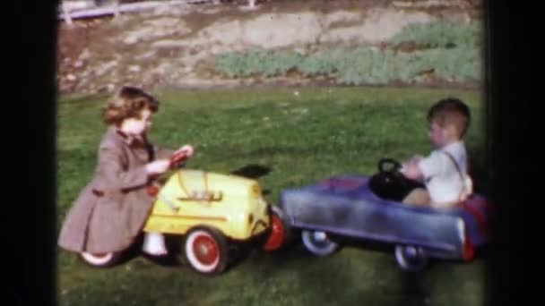 Мальчик и девочка катаются на игрушечных машинах — стоковое видео