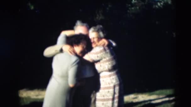 Семья позирует для фотографии, обнимая друг друга — стоковое видео