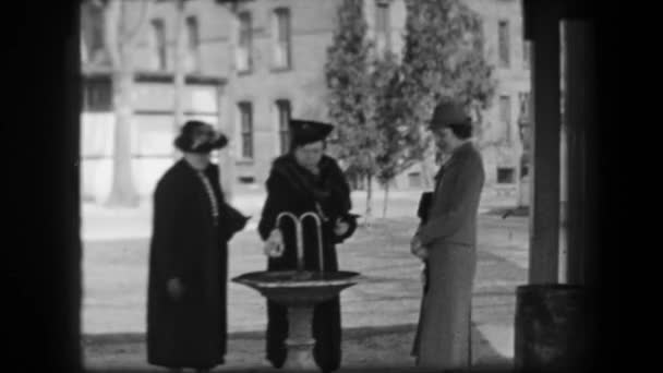 Women filling water bottles from fountain — Stockvideo