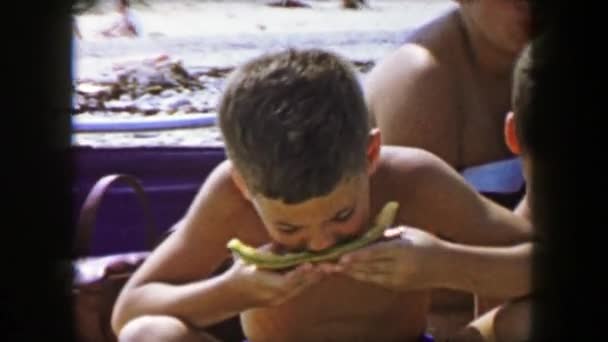 Junge isst Cantaloupe Melonen am Strand — Stockvideo