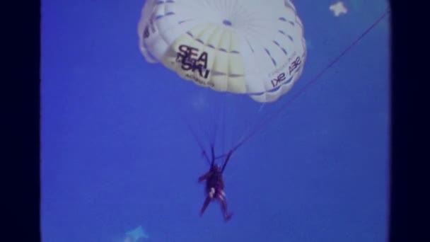 Parasailing man parachute landing on beach