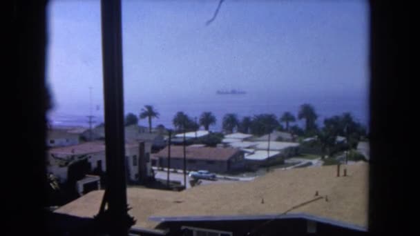 Blick über Häuser und Palmen zum Boot — Stockvideo