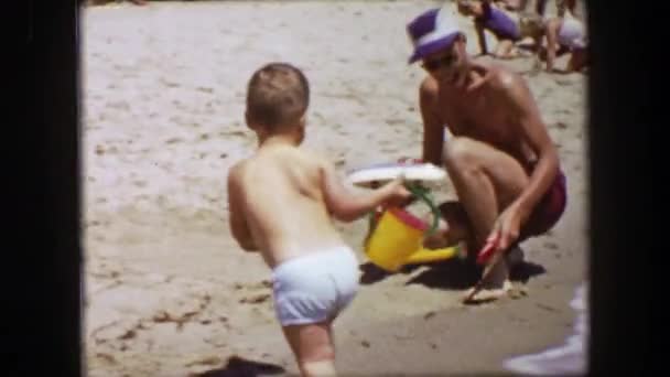 Dad with toddler boy playing with bucket, shovel and toy ship — Stock video