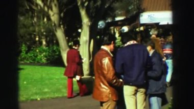 Aile ve arkadaşlar parkta ağaçların çevresinde yürüyüş