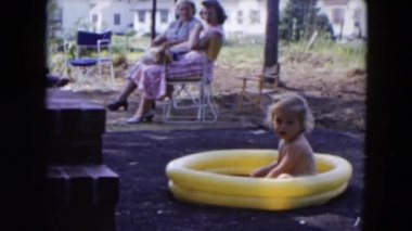 Aile rahatlatıcı bir çocuk bir havuzda çalarken kendi arka bahçesinde