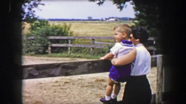 Madre con hijo pequeño viendo jinetes de rancho de caballos — Vídeos de Stock