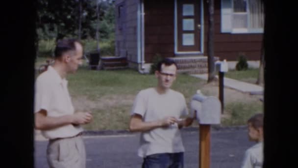 Hombres y un niño instalando un buzón fuera de una casa — Vídeo de stock
