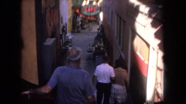 Hombres y una dama caminando por un callejón estrecho — Vídeos de Stock