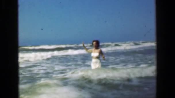 Woman wading into angry ocean — Stock Video