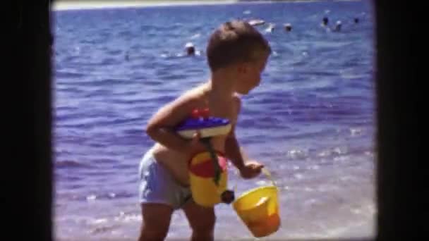 Boy playing on ocean beach shoreline — Stockvideo