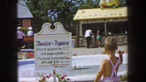 Boy throws coin into water fountain — Stock Video