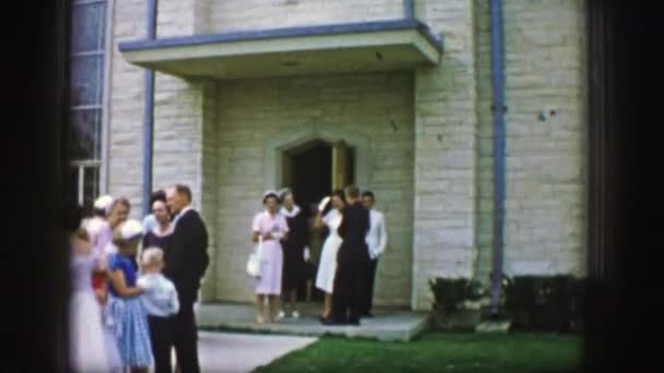 Persone che escono casualmente attraverso la porta d'ingresso di una chiesa — Video Stock