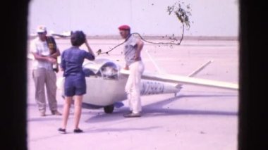 küçük bir uçağın önünde bekleyen bir grup