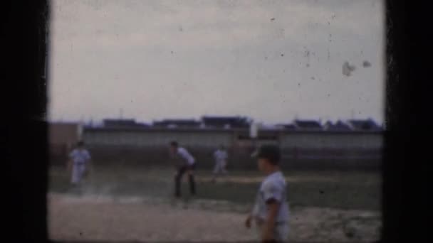 Chicos en uniformes jugando un juego de béisbol en el campo — Vídeos de Stock