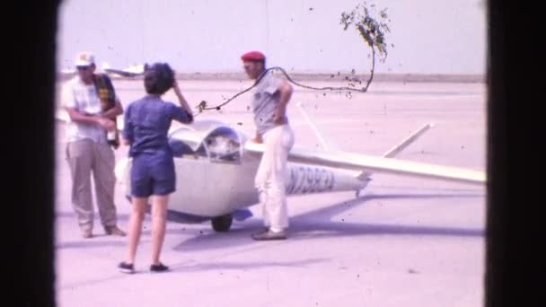 Un grupo de pie frente a un pequeño avión — Vídeos de Stock