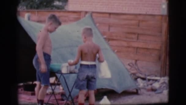 Meninos estão lavando pratos ao ar livre — Vídeo de Stock