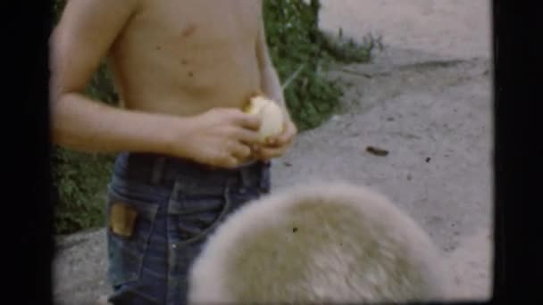 Jongen in afgesneden shorts schillen van vruchten — Stockvideo
