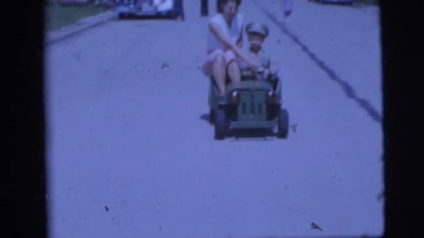 Boy driving a mini army car with mother — Stock Video