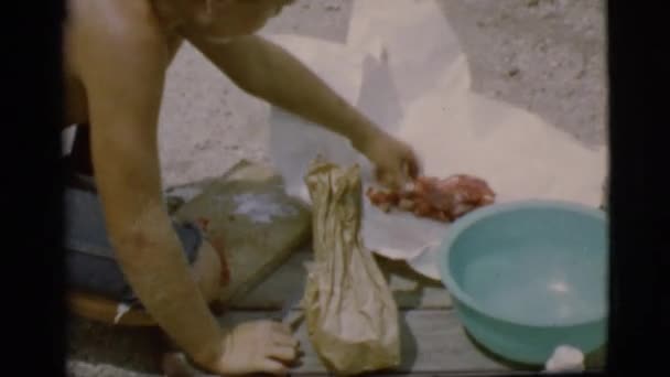 Fiú szeletelő hús a földön — Stock videók