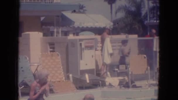 Un niño es visto buceando en el agua en una piscina al aire libre — Vídeo de stock