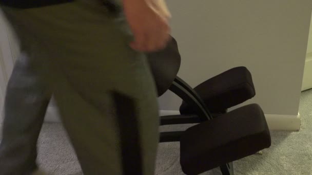 Hombre sentado en silla de rodilla — Vídeos de Stock