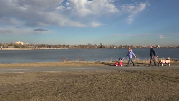 Familia caminando más allá de un lago — Vídeos de Stock