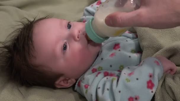 Un bebé bebe leche del biberón — Vídeo de stock