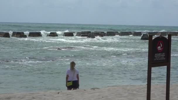 Woman on the beach with a safety sign in frame — Stock Video