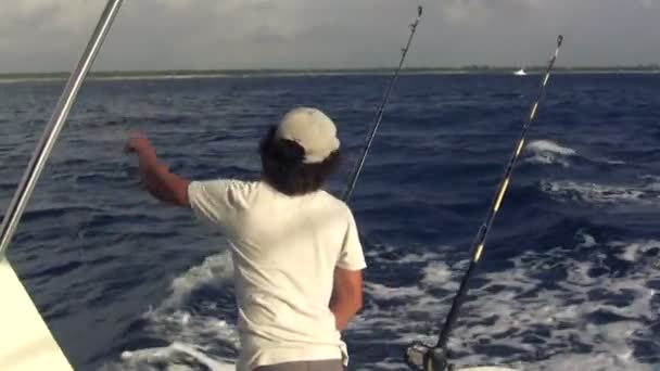 Fisherman tends to the fishing poles and rigging setup — Stock Video